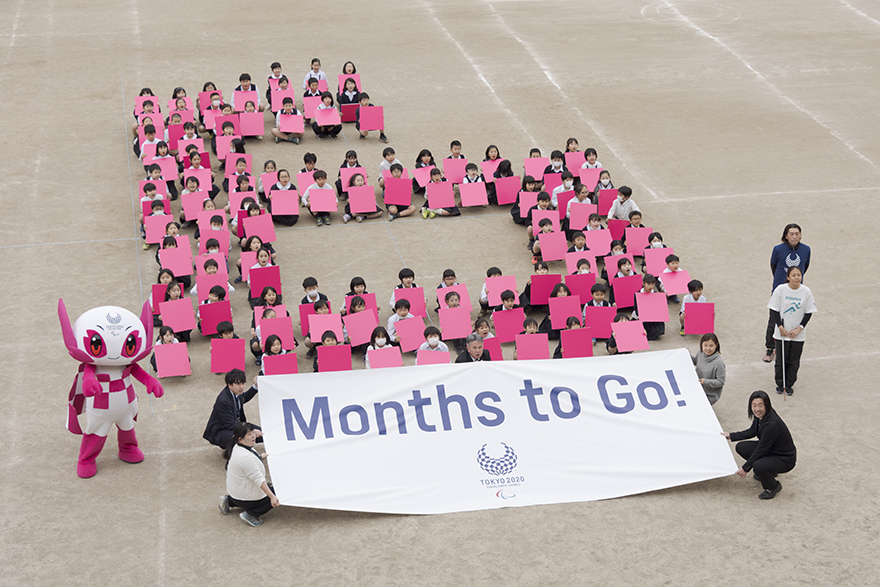 Image of people sitting in the shape of a number 6 with Someity