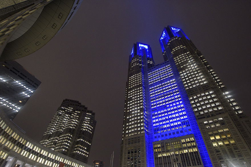 Image of the TMG buildings lit up in blue