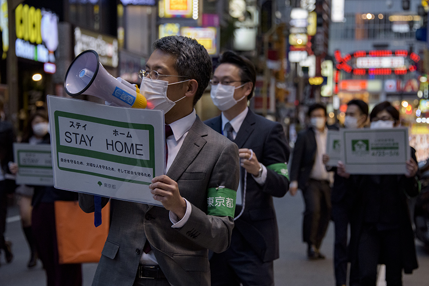 Image of officials with loudspeakers and stay home signs