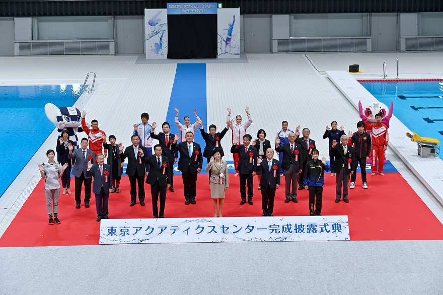 Tokyo Governor and ceremony attendants waving in cheer at the pool side