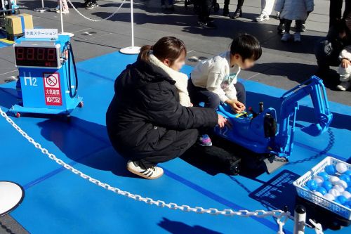 水素で作ったエネルギーで動く遊具で遊ぶこどもたち