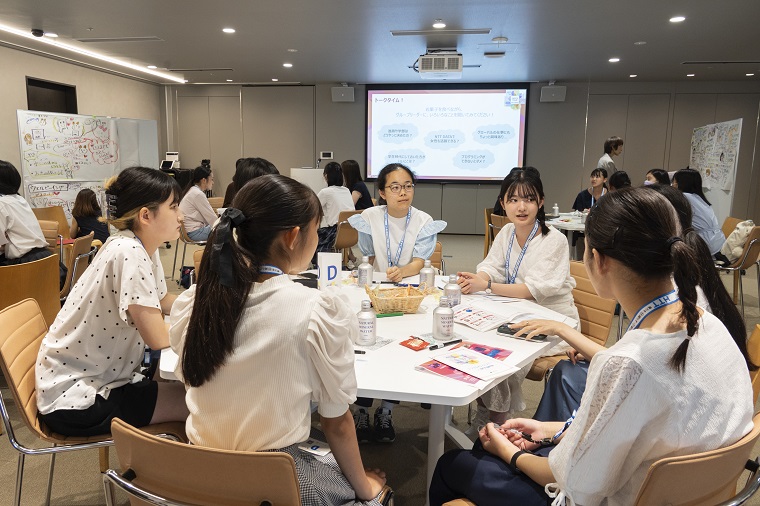 Photo: Students discussing while sitting around a desk