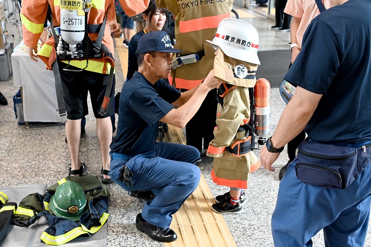 Photo: A child being outfitted with fireproof clothing