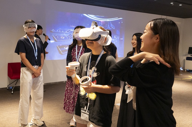 VRヘッドセットを装着したVR体験者と参加者達の画像2