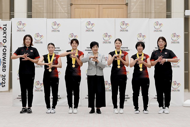 記念撮影をする女子チームメンバーと小池知事の写真