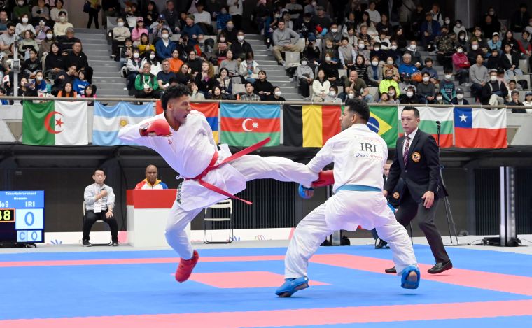 空手の組手で対戦するベネズエラとイランの選手の写真