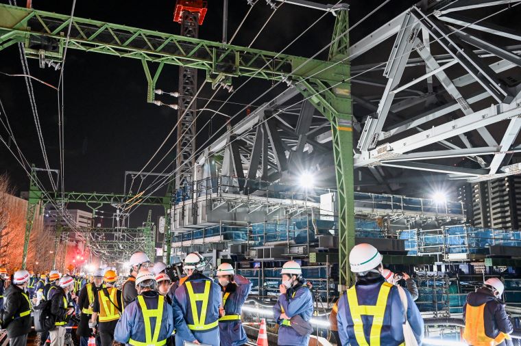 関係者が工事を見守る様子の写真